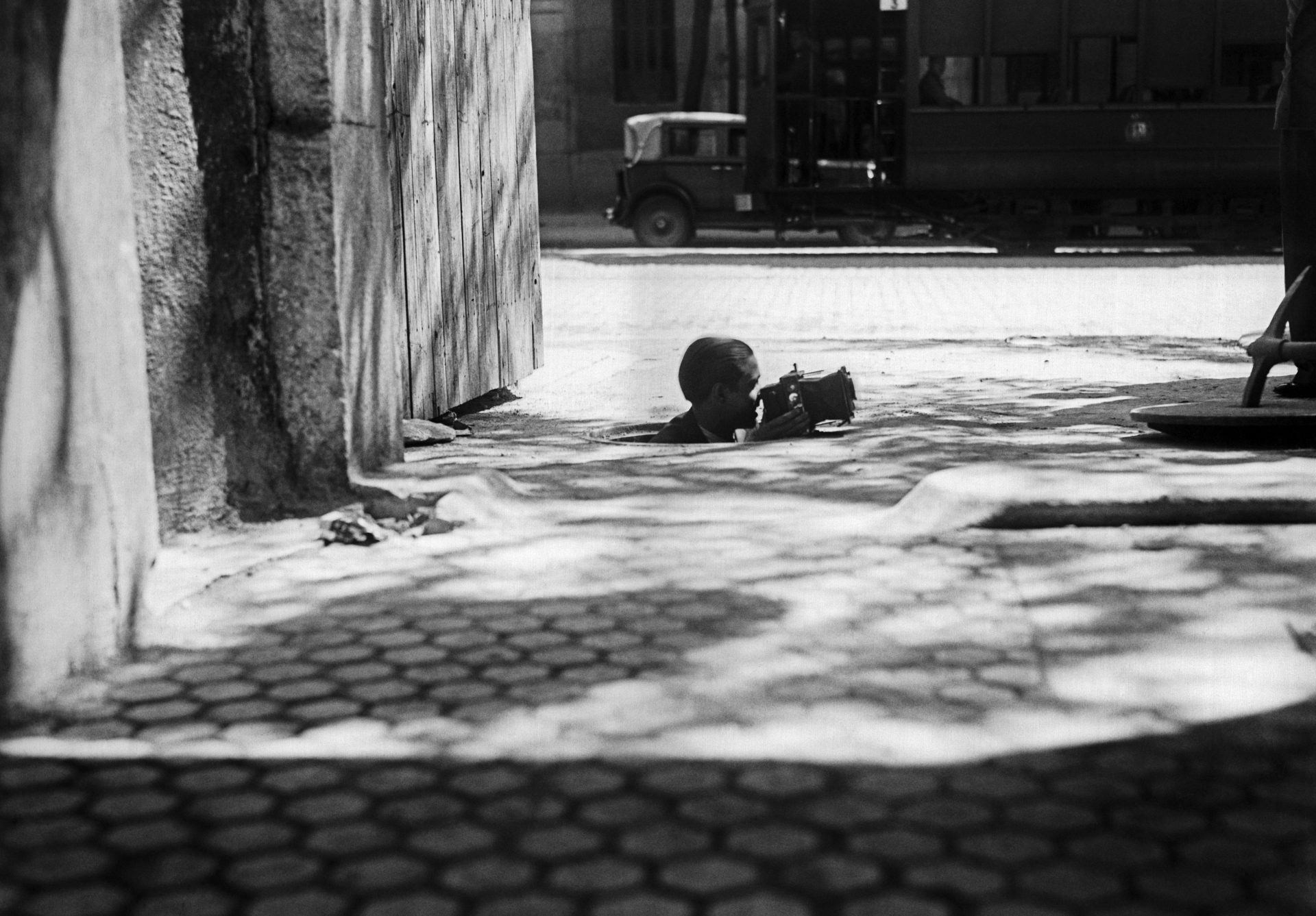 Madrid, 15-9-1934.- Un fotógrafo saca cabeza y cámara por el agujero de una alcantarilla. EFE/Díaz Casariego