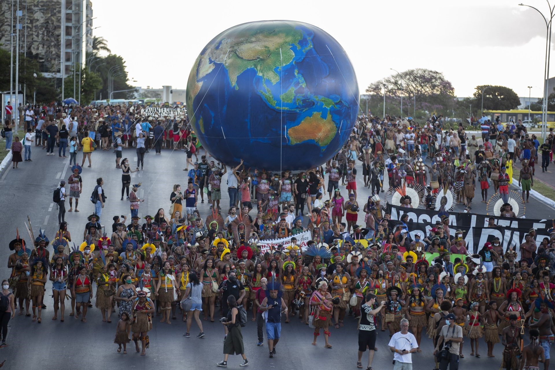 Manifestantes de los pueblos indígenas contra el cambio climático, transportan un globo terráqueo gigante