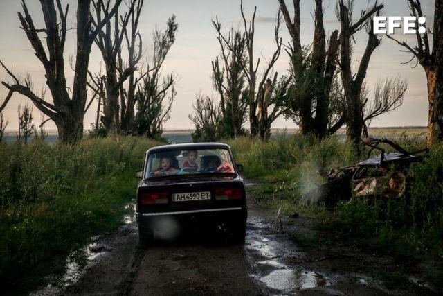 La foto premiada como Imagen del Año, de Oleg Petrasiuk (EPA). (Mykola (41) y su familia conducen en el pueblo de Dovhenke, región de Kharkiv, Ucrania, 15 de julio de 2023. Mykola llegó a la casa destruída de su hermana para recoger el resto de una colmena dañada durante los combates activos en la invasión rusa de Ucrania. Su propia casa en la cercana aldea de Krasnopillia también fue destruida durante los combates, y se vio obligado a trasladarse con su familia a Khrestyshe, donde cría abejas y espera volver algún día a casa. Las tropas rusas entraron en Ucrania el 24 de febrero de 2022, iniciando un conflicto que ha provocado destrucción y una crisis humanitaria.