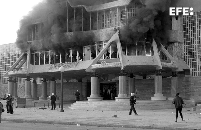 Cartagena (Murcia), 03-02-1992.- Policías antidisturbios protegen el edificio de la Asamblea Regional de Murcia, incendiado por un grupo de incontrolados durante los enfrentamientos entre trabajadores y policía nacional en las inmediaciones. EFE/J.F. Moreno